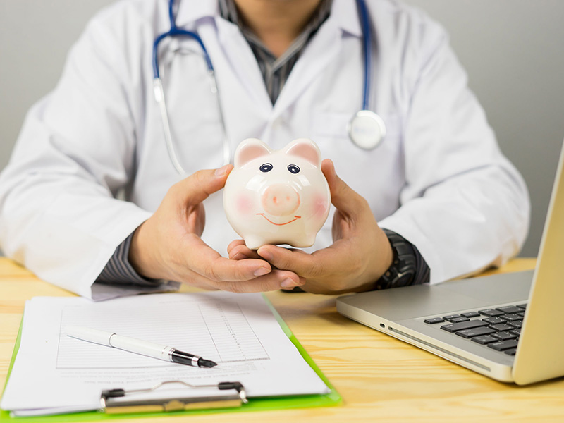 Médecin tenant une tirelire.