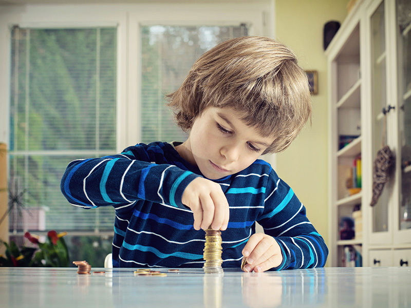 Garçon empilant des pièces de monnaie.