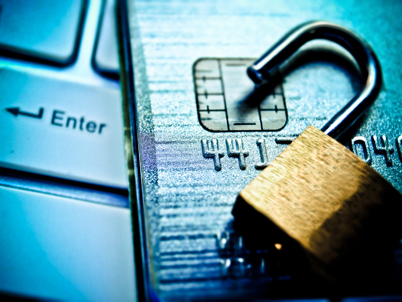 Cadenas sur une carte de crédit posée sur un clavier d'ordinateur.