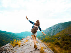 Jeune adulte au sommet d'une montagne