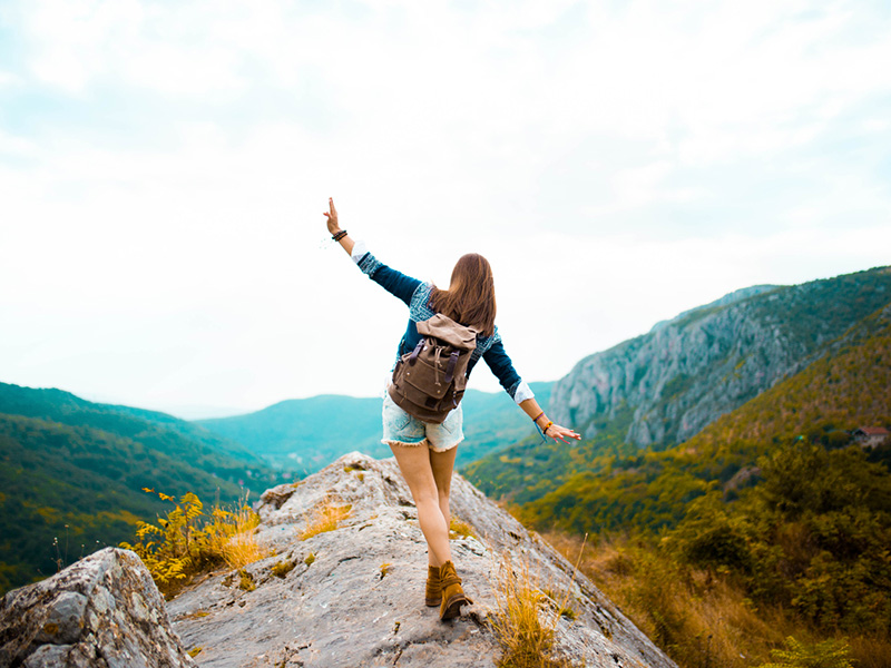 Jeune adulte au sommet d'une montagne