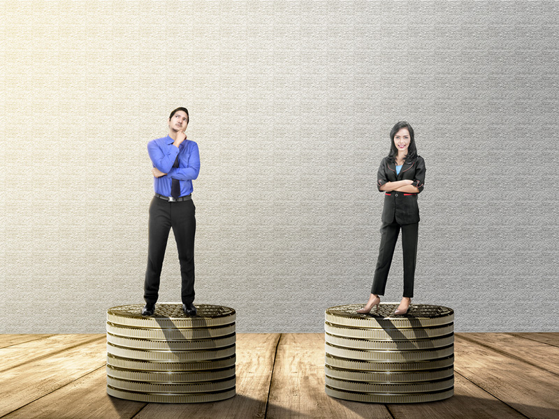 Un homme et une femme se tenant chacun sur une pile de pièces de monnaie.