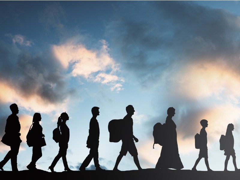 Une file d'immigrant sur un fonds de ciel parsemé de nuages.