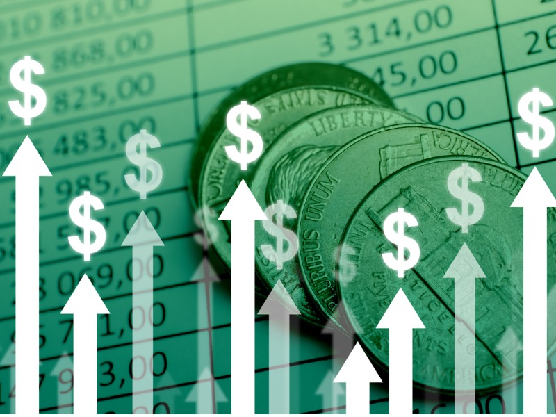 Concept de croissance de devise de dollar avec des flèches vers le haut sur des diagrammes et des fond de pièces de monnaie.